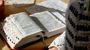 Avoin Raamattu pöydällä ihmisen edessä